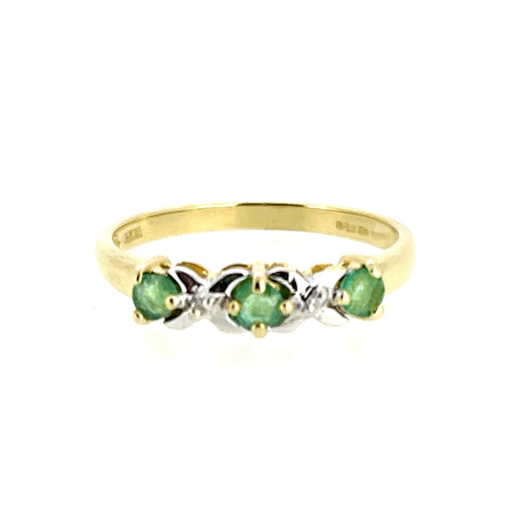 Three round-cut green emeralds and two small diamonds set in a vintage 9ct gold ring